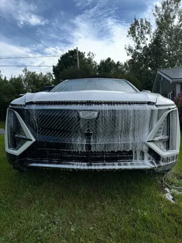 The same Cadillac Lyriq covered in snow foam during the wash