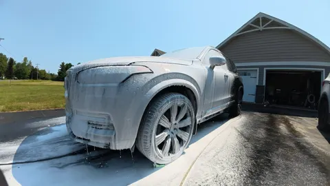 Volvo XC90 under a layer of foam in the driveway