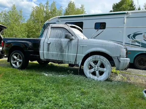 Black Ford Ranger pickup covered in foam during the wash